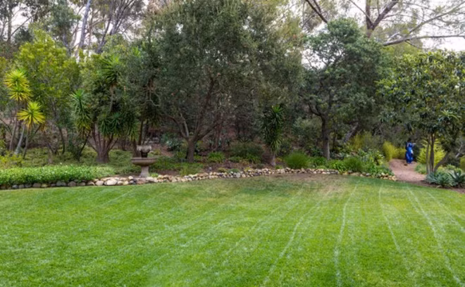 Không gian sân vườn rộng lớn, xanh mướt với bãi cỏ được cắt tỉa cẩn thận.