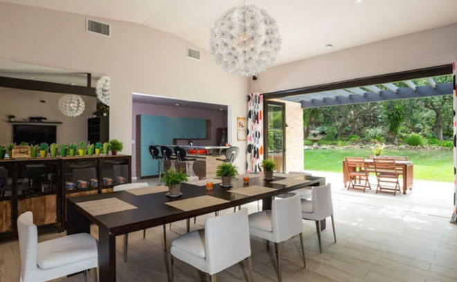 Khu vực ăn uống nằm giữa nhà bếp và phòng khách với điểm nhấn là một chiếc đèn chùm lộng lẫy, tinh xảo. Gần đó là một không gian ăn uống ngoài trời đơn sơ, mộc mạc.