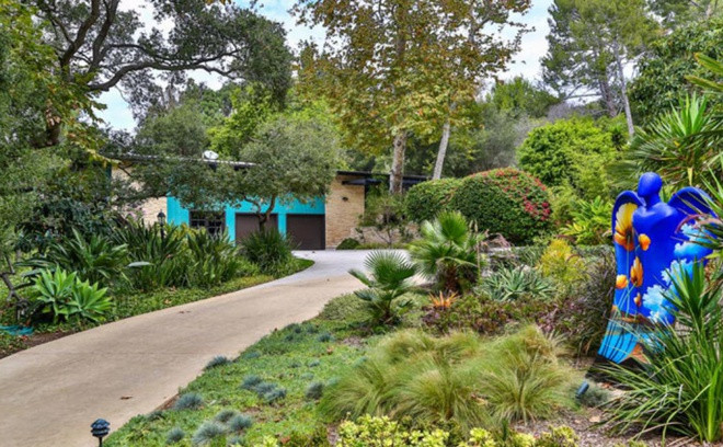 Ngôi nhà mang tông màu xanh ngọc đậm chủ đạo, tọa lạc ở một khu vực kín đáo, được bao quanh bởi hàng cây cao lớn để đảm bảo sự yên tĩnh và riêng tư cho gia chủ.