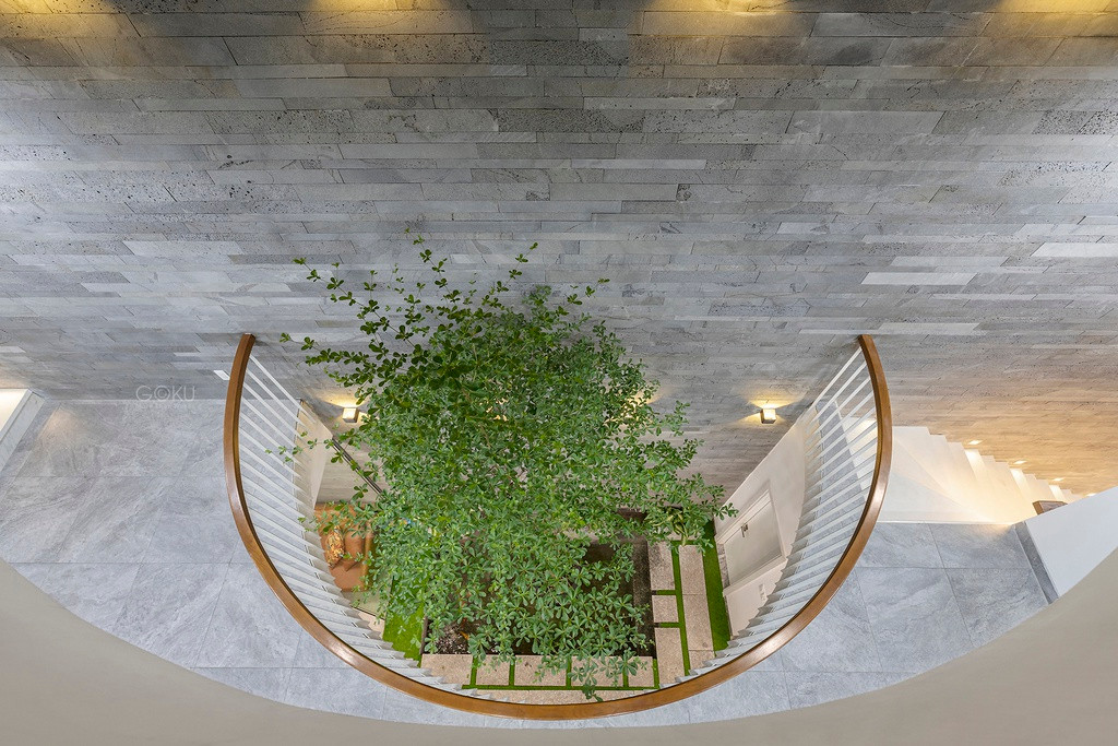 Ánh nắng di chuyển thay đổi theo từng khoảng thời gian trong ngày, kết hợp với hệ khung lam bảo vệ, lan can sắt để tạo ra những bóng đổ hình dáng khác nhau lên bề mặt tường và sàn. Khoảng không thông tầng với hình dáng vòm cung ở giữa ngôi nhà chính là giải pháp mà kiến trúc sư đã sử dụng để kết nối không gian các tầng với nhau.