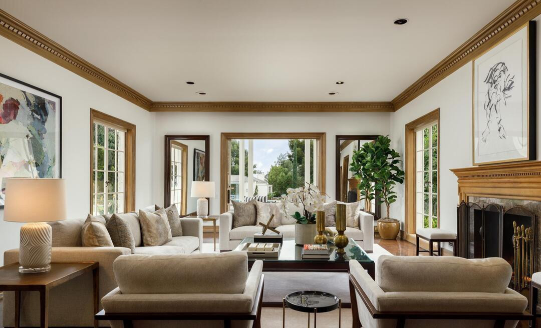 Phòng khách sang trọng, sáng sủa, nổi bật với bộ sofa cỡ lớn và chiếc lò sưởi mang kiểu dáng cổ điển.