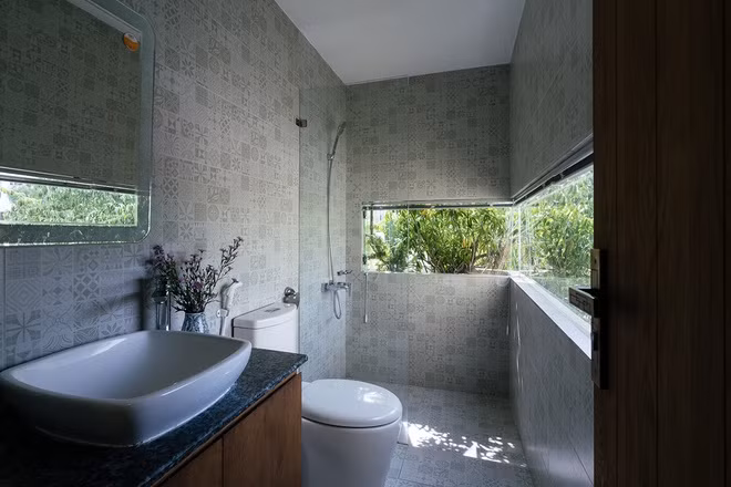 Phòng tắm nằm riêng một chỗ, được đục thủng một khoảng tường để lắp kính lấy sáng.