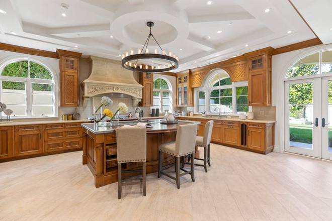 Phòng bếp được trang bị ống khói đá cẩm thạch và bếp La Cornue thủ công. Căn biệt thự đón ánh sáng tự nhiên nhờ hệ thống cửa sổ trải dài từ sàn đến trần và cửa lót kính.