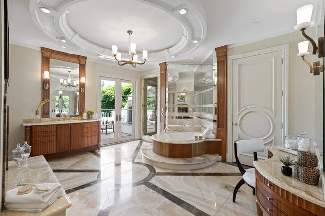 Phòng tắm sang trọng với mặt bàn bằng đá cẩm thạch và gương trang điểm theo tông trắng cổ điển.