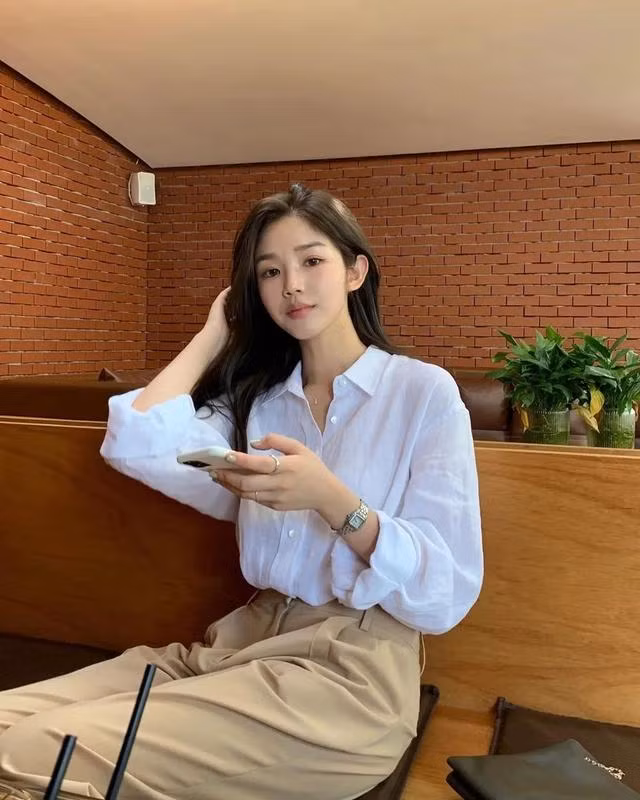 Về khoản giày dép, thay vì bó mình trong những đôi giày công sở có thiết kế nhạt nhòa kém đẹp thì hội gái Hàn sẽ diện giày đế bệt, giày thể thao, hay thậm chí là 1 đôi dép xỏ ngón để tạo nên vẻ mới lạ cho tổng thể trang phục. Cuối cùng nhấn nhá thêm với 1 chiếc túi xách cắp nách, túi đeo ngang eo và 1 vài món phụ kiện như kính râm, chun buộc tóc vải, vòng cổ… là họ đã có set đồ thời thượng chẳng kém nào những diễn viên truyền hình. 2. Style nữ tính điệu đà Không thích style đứng đắn chững chạc thì bạn có thể đổi sang váy vóc yểu điệu, nữ tính. Và để diện váy sao cho đủ thanh lịch, chỉn chu mà vẫn thu hút, thời thượng thì chúng ta cứ copy từ hội gái Hàn là chuẩn bài. Đầu tiên phải nói đến bí kíp chọn váy áo cách điệu. Những mẫu váy áo của họ luôn có thêm chi tiết biến tấu mới mẻ như váy áo tay loe, tay phồng, chiết eo, chân váy xòe, chân váy highlow… để tạo điểm nhấn mới lạ.