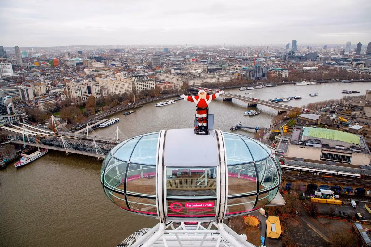 Ông già Noel đứng vẫy chào bên trên nóc một buồng tham quan của London Eye (Vòng quay Thiên niên kỷ) tại Anh, đánh dấu dịp lễ quan trọng cuối năm vào thời gian nhộn nhịp nhất.
