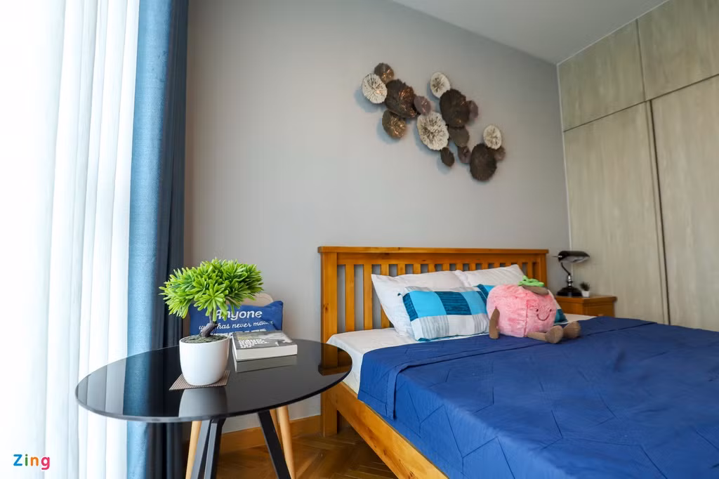 Màu xanh và màu vàng vẫn được lựa chọn làm điểm nhấn, khi tủ quần áo lại có sắc trầm hơn khiến phòng ngủ lớn thêm thoáng đãng, sàn và giường bằng gỗ lại tạo ra cảm giác ấm cúng.