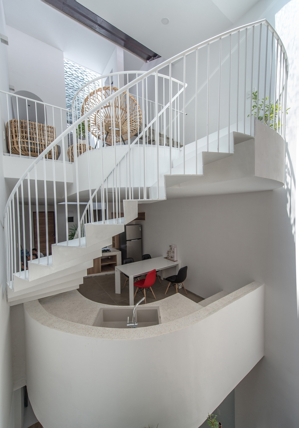 Bếp và phòng ăn – không gian có cường độ sử dụng cao nhất - được bố trí ở trung tâm căn nhà, ở tầng cao giữa phòng mạch và phòng sinh hoạt. Đây là nơi liên kết giữa các thành viên trong gia đình và cũng là nơi tề tựu vào giờ cơm, thời điểm cảm nhận ánh sáng từ hồ sen đáy kính vào sâu bên trong, di chuyển và lay động trên bề mặt tường gạch mộc cuối nhà.