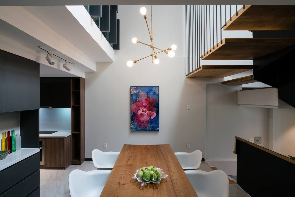 Phòng ăn và bếp chiếm diện tích khá nhỏ so với những không gian khác trong nhà nhưng vẫn đầy đủ tiện nghi và được bố trí hợp lý như hệ tủ bếp kịch trần tối đa hoá việc lưu trữ đồ dùng. Ngoài ra, khu vực bếp còn kết hợp thêm tranh treo tường mang lại không gian nấu nướng gọn gàng nhưng vẫn tinh tế.