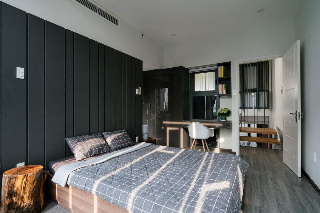 Phòng ngủ nhỏ đầy đủ tiện nghi với tông màu trung tính từ đồ nội thất. Căn phòng cũng đón nhận ánh sáng tự nhiên từ hệ cửa lam tương tự như phòng khách.