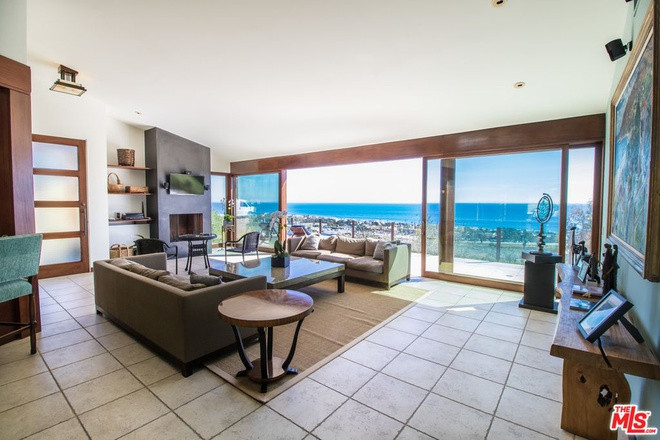 Phòng khách thoáng đãng, nằm sát hiên nhà, tràn ngập ánh sáng tự nhiên nhờ vào các cánh cửa kính cỡ lớn.