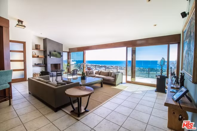 Phòng khách thoáng đãng, nằm sát hiên nhà, tràn ngập ánh sáng tự nhiên nhờ vào các cánh cửa kính cỡ lớn.