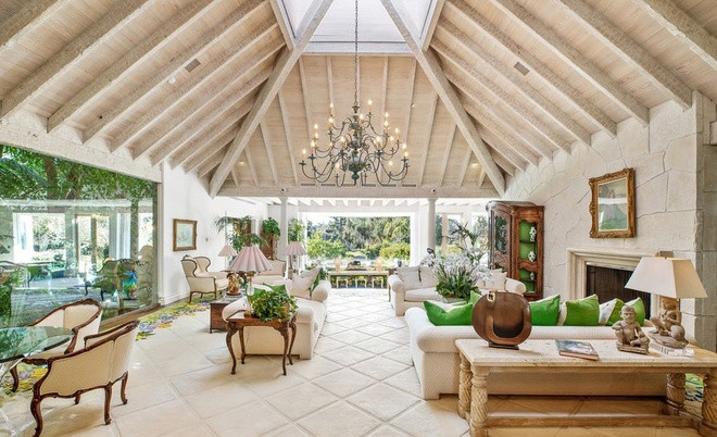 Phòng khách rộng rãi, thoáng đãng, hướng ra không gian sân vườn. Căn phòng nổi bật với đèn chùm, lò sưởi và nhiều chi tiết tinh xảo.