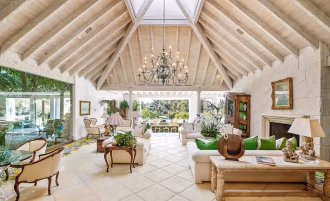 Phòng khách rộng rãi, thoáng đãng, hướng ra không gian sân vườn. Căn phòng nổi bật với đèn chùm, lò sưởi và nhiều chi tiết tinh xảo.