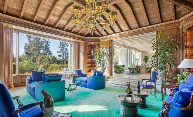 Phòng đọc sách với tường lát gỗ cứng được bài trí tinh tế, hài hòa. Điểm nhấn ở đây là bộ ghế màu xanh navy.