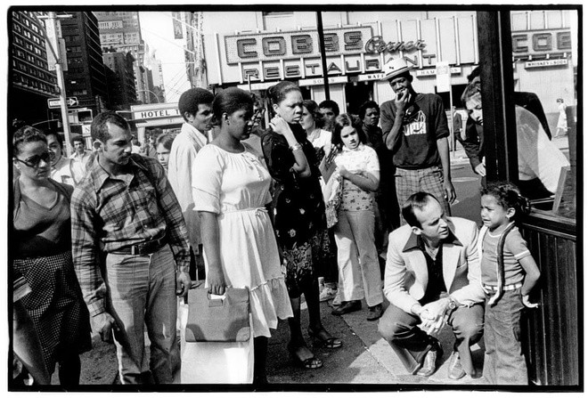 Godlis chụp ảnh đường phố, đúng như ông miêu tả, như một tay lính "bắn tỉa". Bức hình này chụp tại Quảng trường Thời đại năm 1979, ngay cả ông cũng không biết chuyện gì đang xảy ra. Tất cả điều chúng ta thấy là một đứa trẻ đang khóc và những người lớn chạy đến tìm hiểu sự việc. "New York là thành phố bận rộn. Nhưng nhìn vào đây, có lẽ, tôi yên tâm phần nào vì đứa trẻ vẫn được người xung quanh quan tâm", Godlis bình luận về tấm hình này.