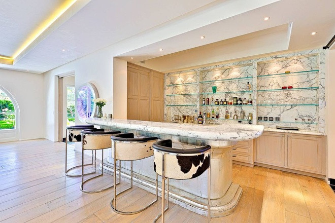 Một quầy bar nhỏ nhắn với bàn đá cẩm thạch được bài trí gọn gàng và một hầm rượu gần đó có sức chứa hàng trăm chai. Đây là một không gian thú vị để đón tiếp bạn bè.