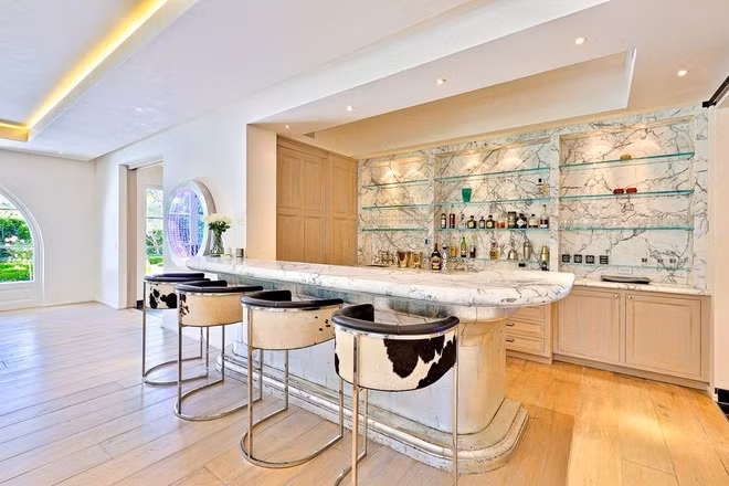 Một quầy bar nhỏ nhắn với bàn đá cẩm thạch được bài trí gọn gàng và một hầm rượu gần đó có sức chứa hàng trăm chai. Đây là một không gian thú vị để đón tiếp bạn bè.