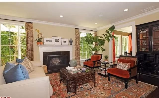 Nhiều không gian sinh hoạt bên trong căn biệt thự được lát sàn gỗ cứng màu nâu đậm. Phòng khách sang trọng, sáng sủa, nổi bật với tấm thảm có họa tiết tinh xảo.