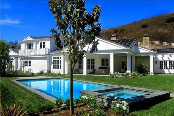 Hồ bơi và bồn tắm nước nóng sử dụng năng lượng trời nằm giữa khu vườn rộng lớn với bãi cỏ xanh mướt được cắt tỉa cẩn thận.