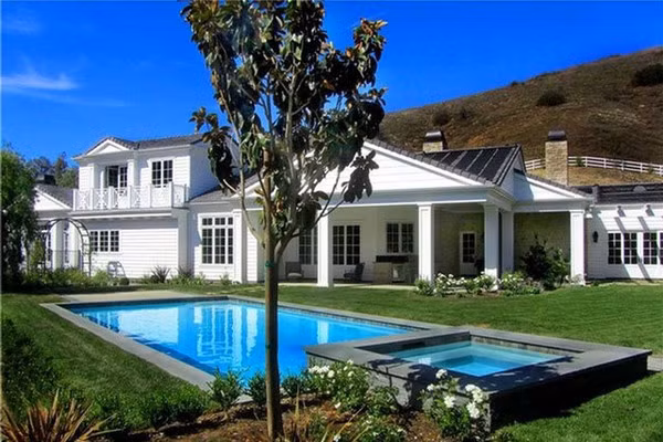 Hồ bơi và bồn tắm nước nóng sử dụng năng lượng trời nằm giữa khu vườn rộng lớn với bãi cỏ xanh mướt được cắt tỉa cẩn thận.