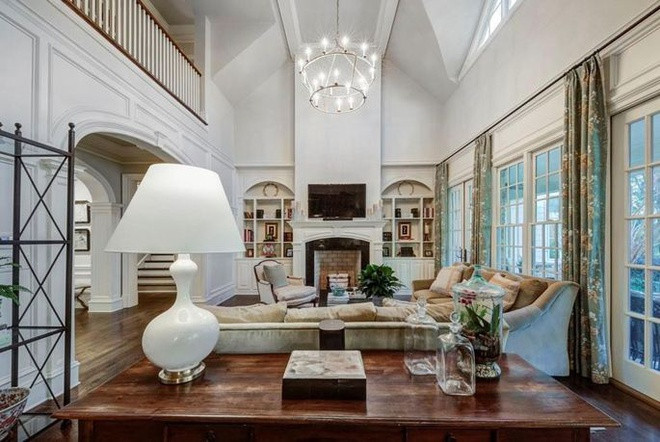 Phòng khách sang trọng, thoáng đãng với trần nhà cao và những cánh cửa mở ra sân vườn. Sàn gỗ cứng cùng bộ sofa cỡ lớn đem lại cảm giác ấm áp cho không gian này.