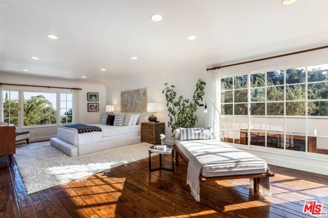 Phòng ngủ chính rộng lớn, sang trọng, tràn ngập ánh sáng tự nhiên. Sàn gỗ cứng tạo những đường nét hoài cổ, còn những nội thất màu trắng đem đến cảm giác dịu nhẹ.