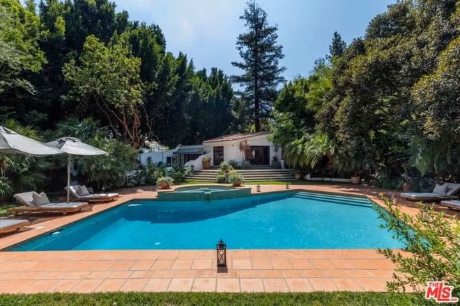 Hồ bơi và bồn tắm nước nóng ngoài trời được bao quanh bởi hàng cây cao nhằm đảm bảo sự riêng tư cho gia chủ.