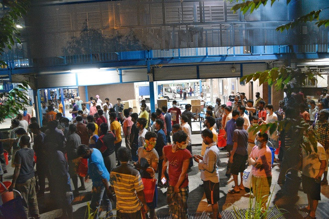 Những lao động tại đây vẫn xếp hàng để lấy đồ ăn và quét vân tay khi ra vào trước khi các ca nhiễm tại đây được phát hiện. Ảnh: Reuters.