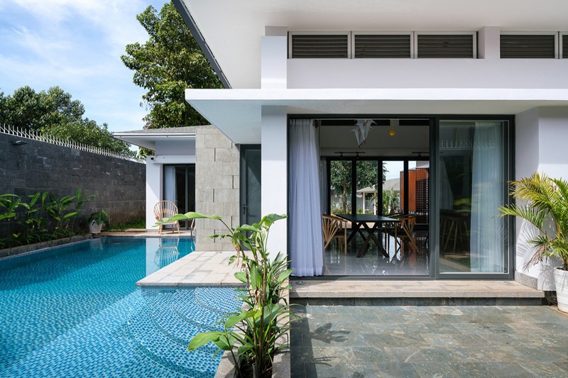 Phía sau phòng ăn là khoảng sân sau, kế bên một hồ bơi xanh mát.