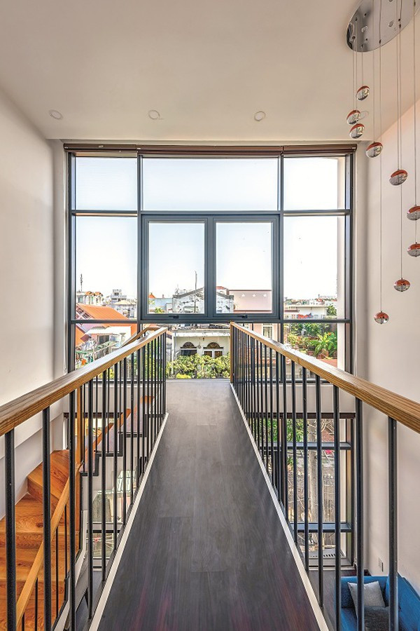 Mặc dù ngôi nhà có diện tích không lớn nhưng những khoảng thông tầng đem lại hiệu quả thoáng rộng đến bất ngờ, xóa bỏ cảm giác nhà lô phố.