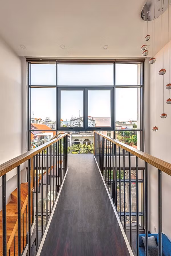 Mặc dù ngôi nhà có diện tích không lớn nhưng những khoảng thông tầng đem lại hiệu quả thoáng rộng đến bất ngờ, xóa bỏ cảm giác nhà lô phố.