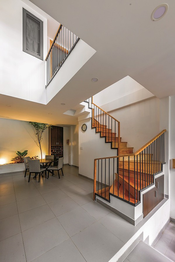 Phía bên kia khoảng thông tầng là cầu thang lên tầng 2. Gầm cầu thang được khéo léo tận dụng làm phòng vệ sinh.