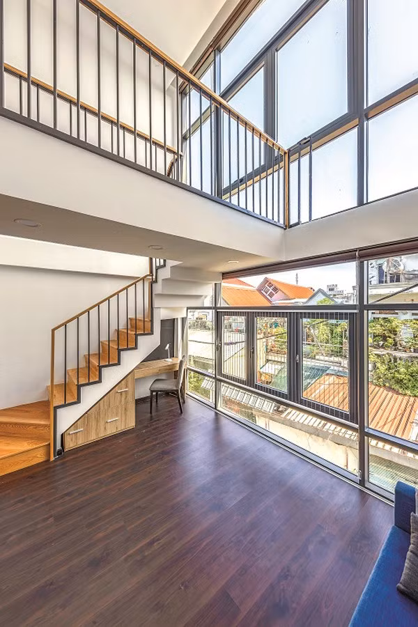 Sàn tầng 2 trước nhà là nơi học và giải trí của trẻ con. Từ đây lên tầng 3 cầu thang được đẩy về phía trước nhà. Khoảng thông tầng khác từ tầng 2 lên tầng 3 tạo cảm giác hành lang phía trên như một chiếc cầu bắc giữa không gian.