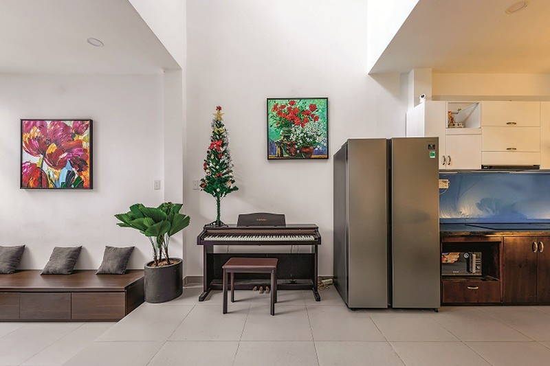 Giữa phòng khách và phòng bếp – ăn là một khoảng thông tầng khá lớn. Phía dưới kê cây đàn piano dành cho con.