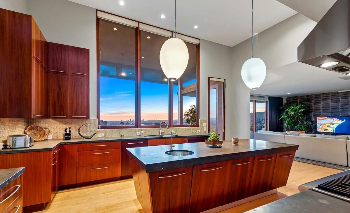 Nhà bếp rộng lớn, mang phong cách hiện đại và cởi mở, được trang hoàng với những nội thất bằng gỗ cao cấp cùng các thiết bị nấu nướng hiện đại.