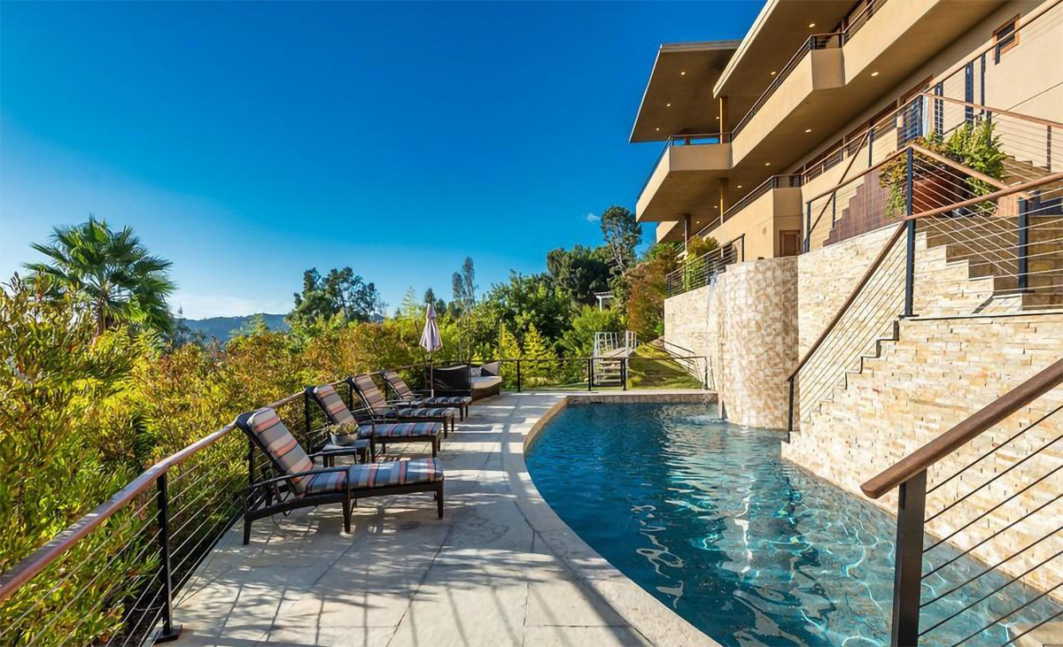 Không gian thư giãn bên ngoài bao gồm hồ bơi, bồn ngâm nước nóng, và khu vực tắm nắng, ngắm cảnh.