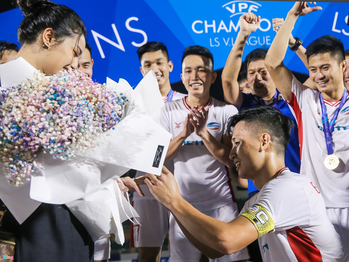 Sau khi cùng CLB Viettel nâng cúp vô địch V.League 2020 trên sân Thống Nhất tối 8/11, Bùi Tiến Dũng đã cầu hôn Khánh Linh trước sự cổ vũ cuồng nhiệt của đồng đội. Khánh Linh vô cùng hạnh phúc trước món quà đặc biệt mà Tiến Dũng dành cho mình. Khi được hỏi về kế hoạch tổ chức đám cưới, cô từ chối chia sẻ thời gian cụ thể vì muốn "giữ bí mật cho mọi người ngạc nhiên". Ảnh: Y Kiện.