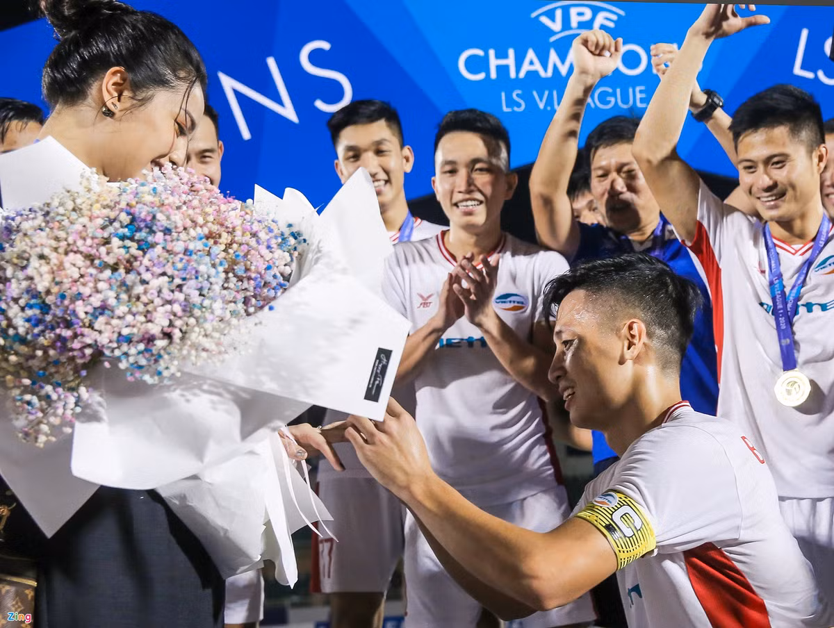Sau khi cùng CLB Viettel nâng cúp vô địch V.League 2020 trên sân Thống Nhất tối 8/11, Bùi Tiến Dũng đã cầu hôn Khánh Linh trước sự cổ vũ cuồng nhiệt của đồng đội. Khánh Linh vô cùng hạnh phúc trước món quà đặc biệt mà Tiến Dũng dành cho mình. Khi được hỏi về kế hoạch tổ chức đám cưới, cô từ chối chia sẻ thời gian cụ thể vì muốn "giữ bí mật cho mọi người ngạc nhiên". Ảnh: Y Kiện.