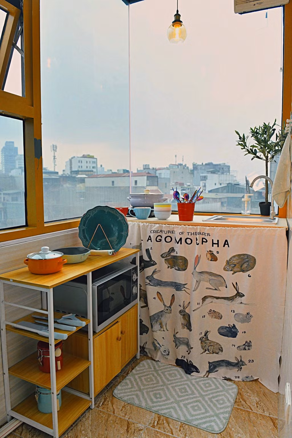 Khu vực bếp không quá cầu kì với những dụng cụ cần thiết có màu sắc tươi sáng được đặt cạnh cửa sổ thông gió cùng khung cảnh trên cao lãng mạn.