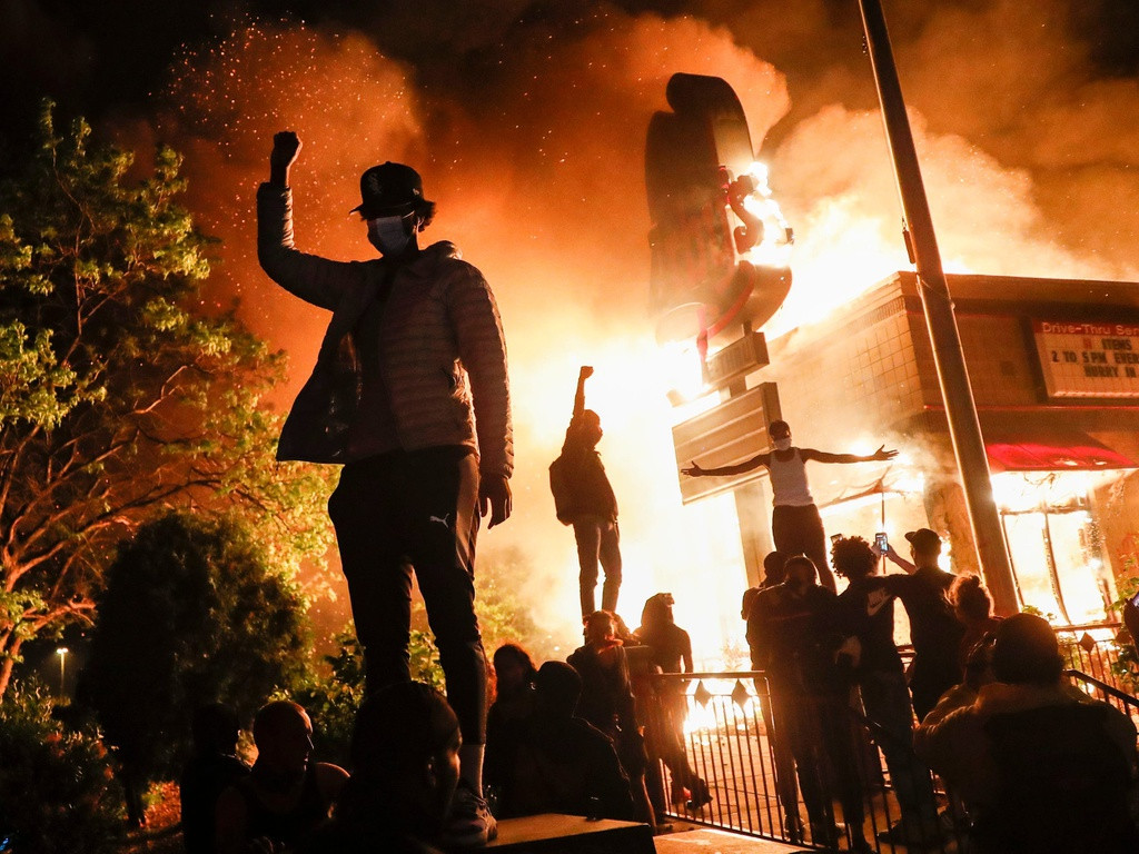 Một số cửa hàng kém may mắn hơn như cửa hàng thức ăn nhanh trong hình, bị đốt cháy hoàn toàn bởi những người biểu tình quá khích. Ảnh: AP.