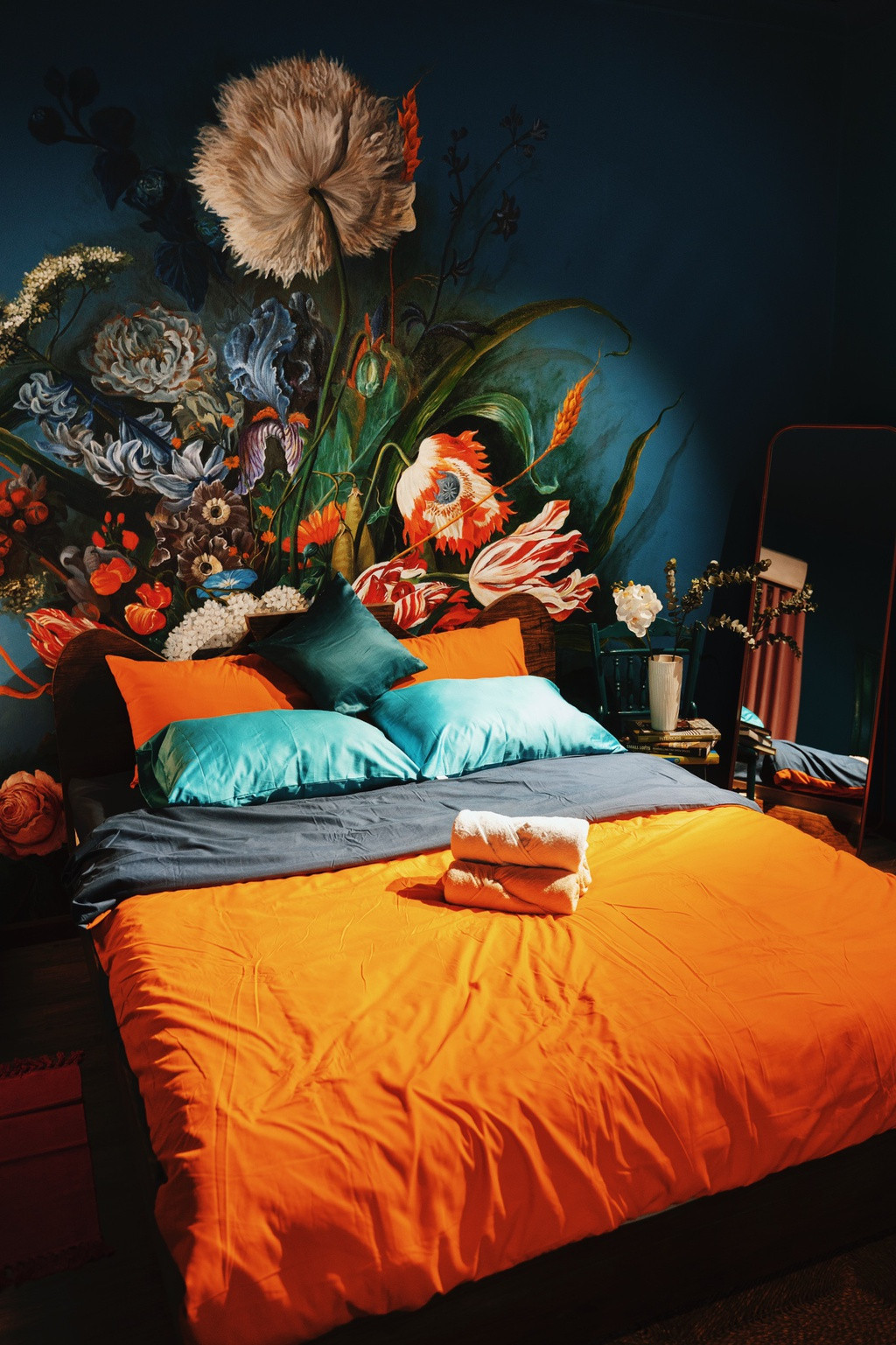 Phòng ngủ còn lại trên tầng 2 vẫn giữ mạch ý tưởng như tầng trệt nhưng thay đổi hình trang trí bằng những bông hoa rừng nở rộ. Bên cạnh đó, chiếc gương lớn kết hợp với bàn ghế gỗ hướng ra cửa sổ tạo thêm sự cổ kính cho căn phòng.