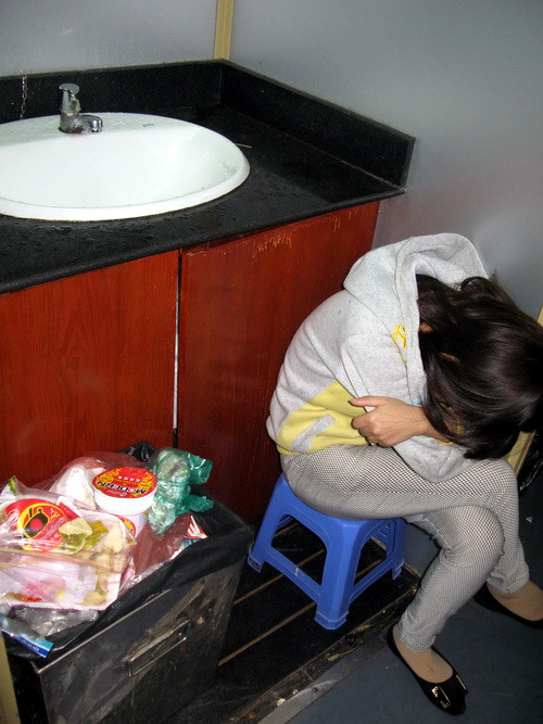 Ngồi ngủ bên cạnh bồn vệ sinh.