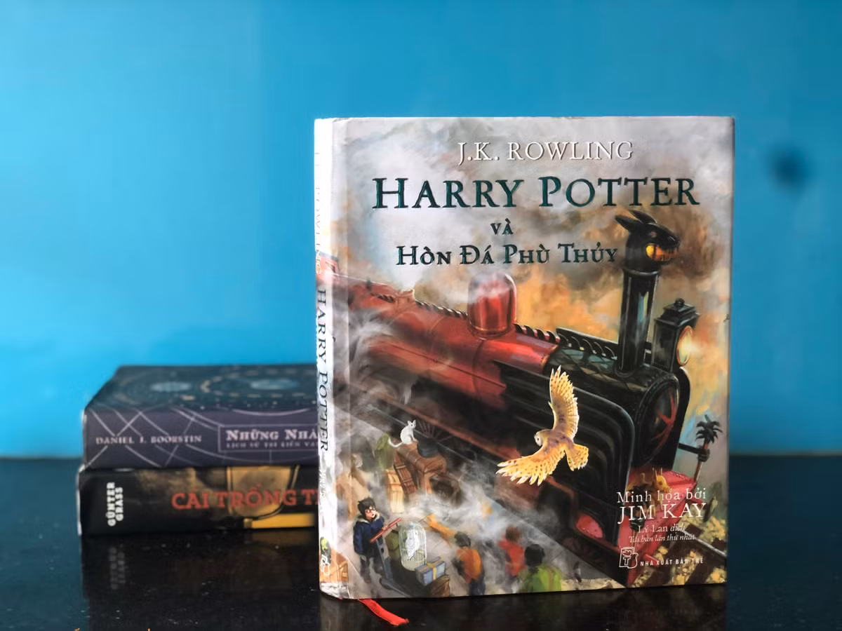  Harry Potter và hòn đá phù thủy là cuốn đầu trong loạt tiểu thuyết Harry Potter của J. K. Rowling, sách đã bán 107 triệu bản. Nội dung sách kể về Harry Potter, thiếu niên mồ côi cha mẹ, sống cùng dì và dượng. Cậu chỉ biết về tiềm năng phép thuật của mình sau khi nhận thư mời nhập học tại Học viện Ma thuật và Pháp thuật Hogwarts vào đúng vào dịp sinh nhật thứ 11. Tập truyện kể về năm học đầu tiên của Harry, sát cánh bên những người bạn như Ron, Hermione... Được bạn bè giúp sức, Harry chiến đấu chống lại sự trở lại của chúa tể hắc ám Voldemort, kẻ đã sát hại cha mẹ cậu. Ảnh: Y. N.