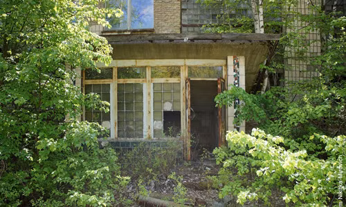 Lối vào trường học ở Pripyat, với những cánh cửa sổ vỡ kính, khung sắt hoen rỉ theo thời gian.