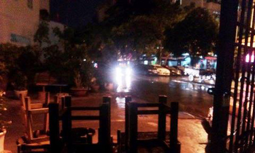 Bàn ghế bị gió lốc thổi văng, ngoài đường vắng người qua lại.