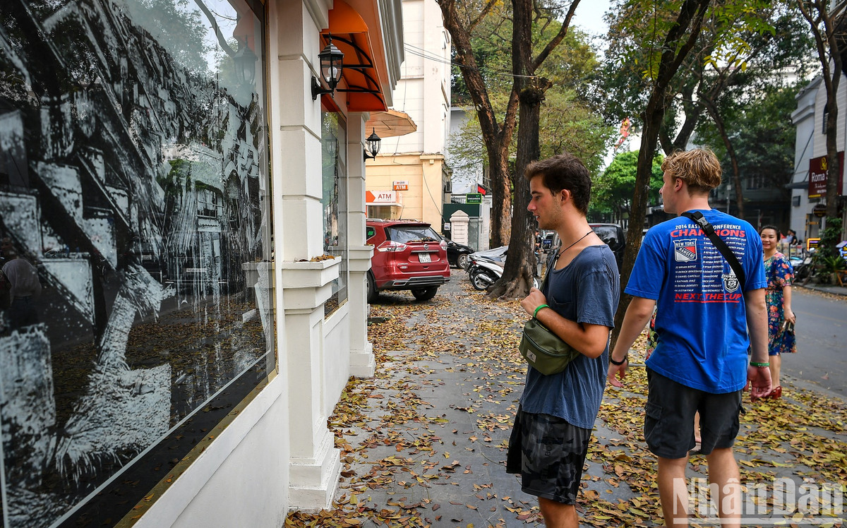 Du khách chiêm ngưỡng hình ảnh về Hà Nội xưa trên những bức tường chung quanh tòa soạn Báo Nhân Dân.