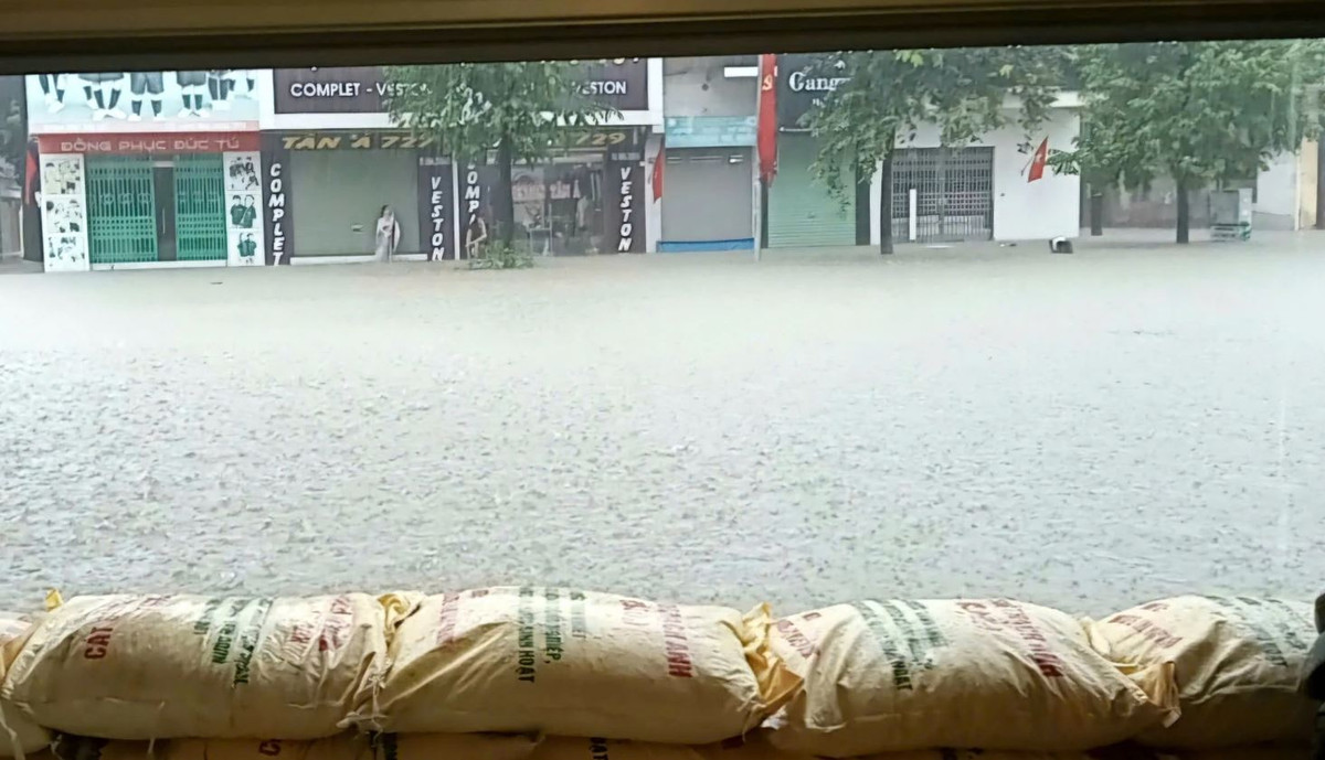 Các tuyến đường trung tâm ngập sâu trong nước. Một số khu vực trũng thấp nước ngập cả vào nhà dân. Người dân phải đắp bao cát để ngăn nước tràn vào nhà.