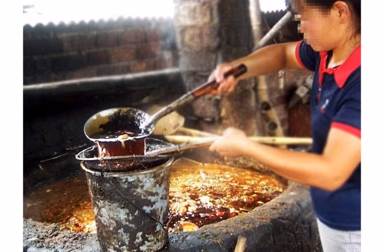 Người chế dầu bẩn dùng vợt để vớt lên những rác thải dạng rắn như xác động vật chết, xương, túi nylon…