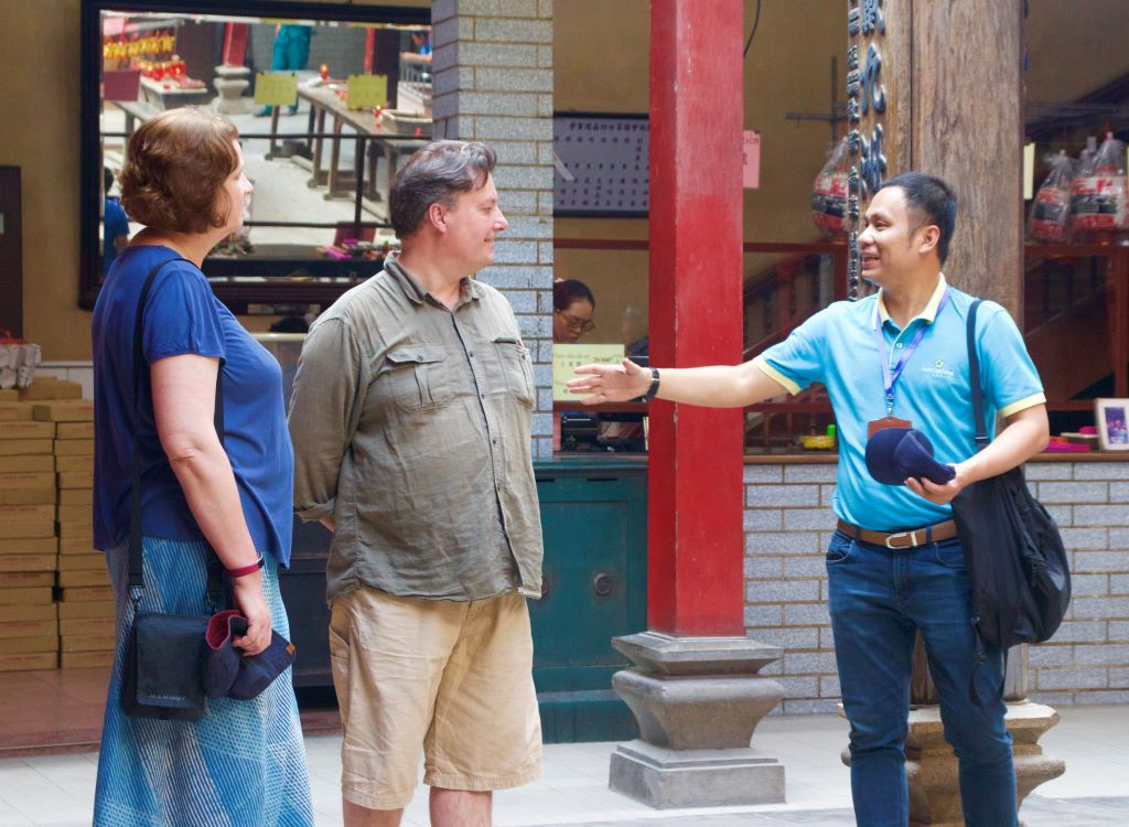 Hướng dẫn viên du lịch (bên phải ngoài cùng) nhiệt tình giới thiệu về chùa Bà Thiên Hậu đến khách quốc tế. Vào những ngày giáp Tết, chùa đón nhiều lượng khách trong và ngoài nước đến tham quan. Ảnh: Lạc Hà